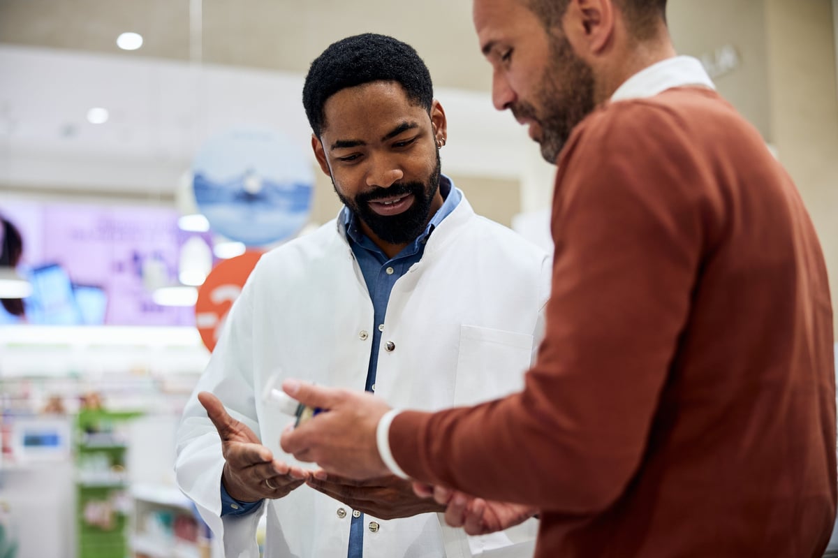 Pharmacist discussing and providing medication advice to a customer in a modern pharmacy