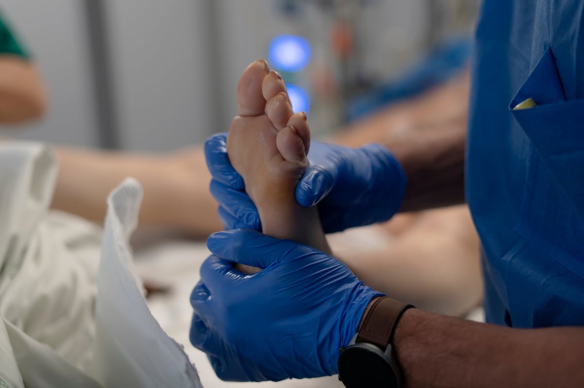 Medical professional examining a patient's foot in a clinic setting